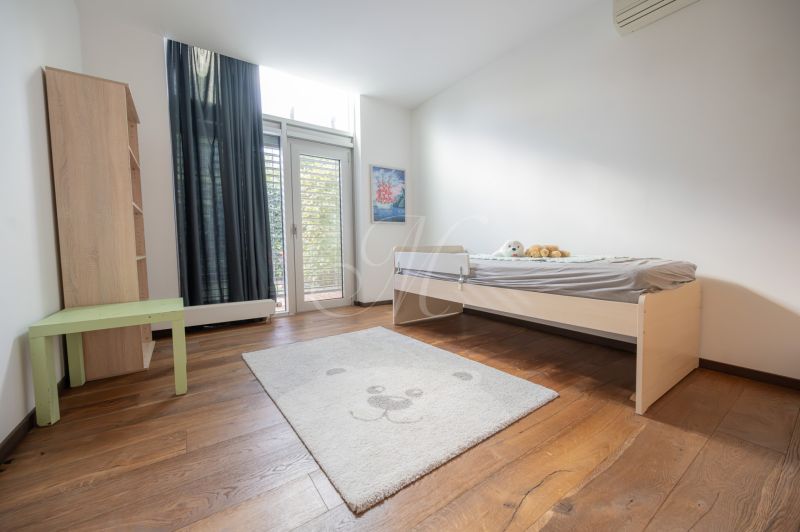 A children's room with a light bed and a wooden decor floor in a 4-room apartment.