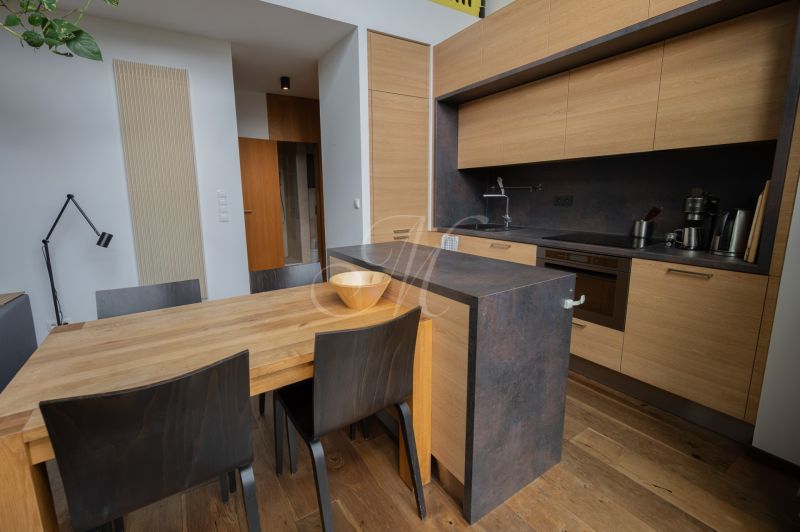 A kitchen in a 4-room apartment with wood-patterned floors and modern furniture.
