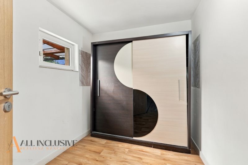 Built-in wardrobe with sliding doors and floor with wood decor in a family house.