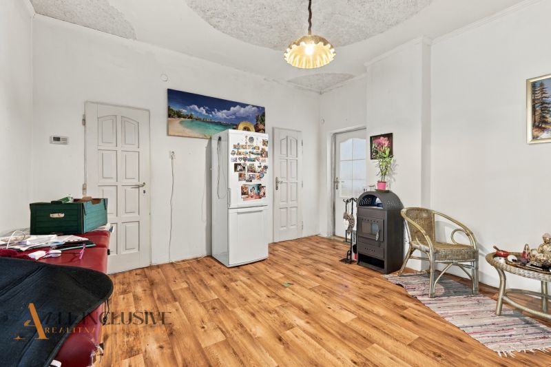 A room in a family house with a wooden decor floor and wall decorations.