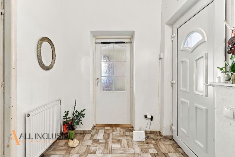 A hallway of a family house with white doors and a decorative mirror on the wall.