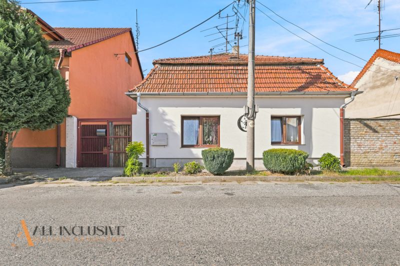 A family house in Komárno with a white facade, red roof, and well-maintained garden.