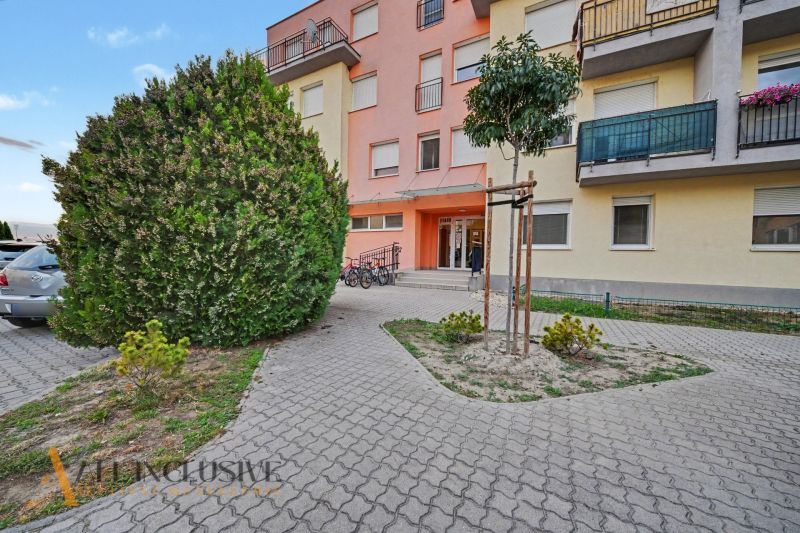 The building on Platan Street in Šamorín with bicycles at the entrance and landscaping.