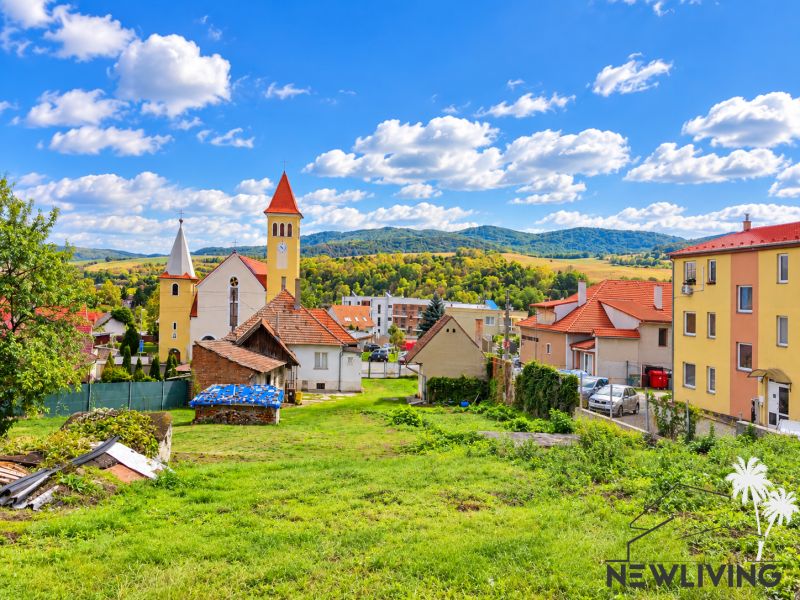 A church surrounded by houses and green landscape in the village of Banka on Topoľčianska Street.