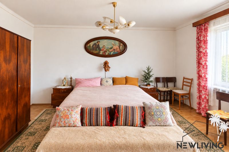 A bedroom in a family house with a stylized interior, a painting, and decorative pillows.