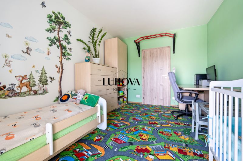 Children's room in a 3-room apartment with playful wallpaper and a colorful carpet.