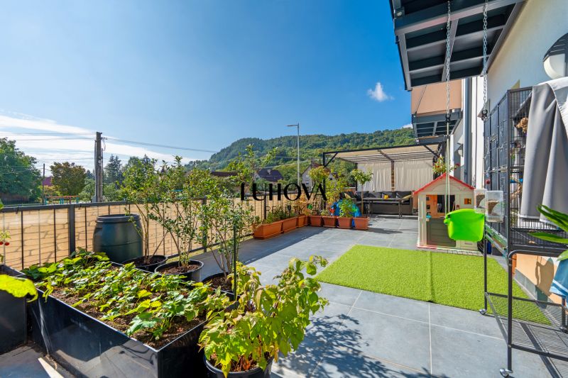 Terrace in a 3-room apartment with a view, plants, and a children's playhouse in Mikušovce.