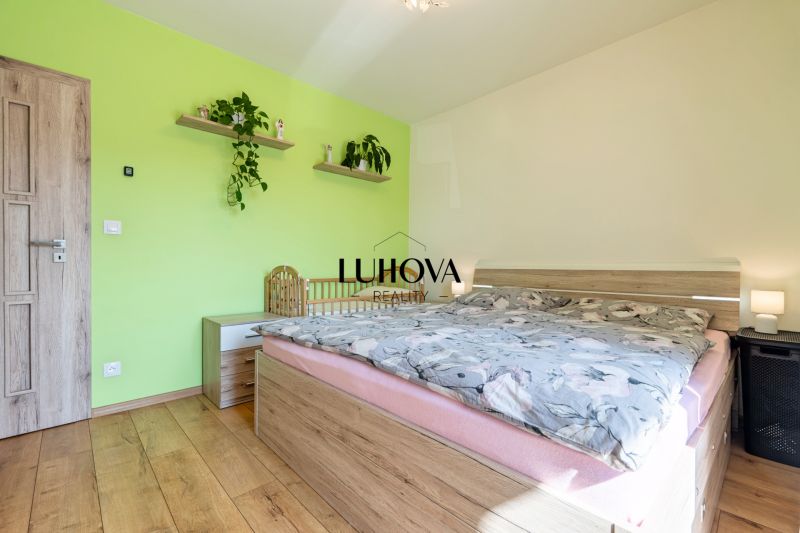 Bedroom in a three-room apartment decorated with a green wall, floor with wood decor.