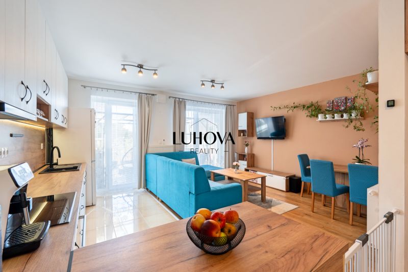 Open kitchen and living area in a 3-room apartment with a wooden decor floor.