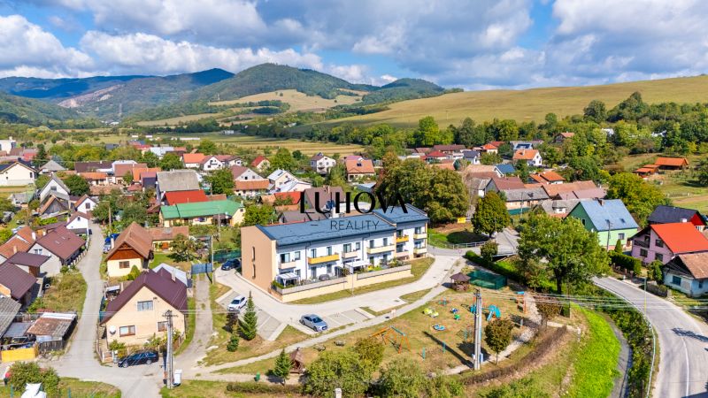 A view of 3-room apartments in Mikušovce with surrounding greenery and hills.