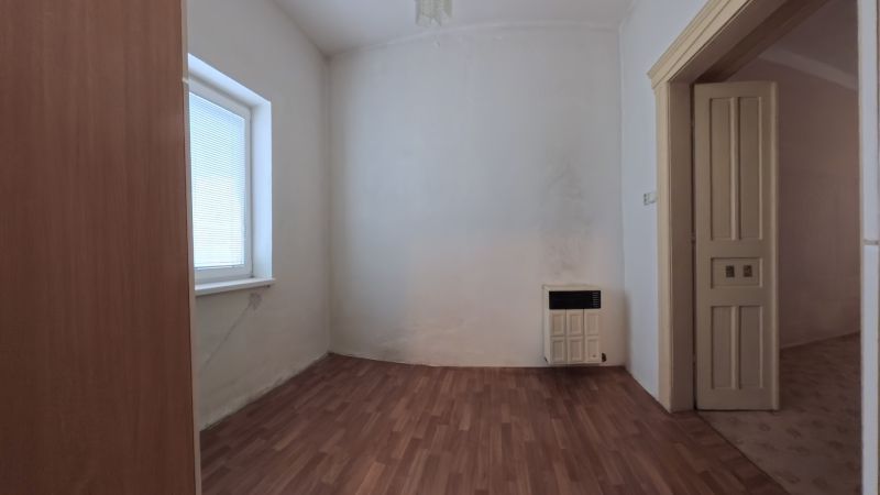 A room in a family house with a wooden decor floor and a heating unit.
