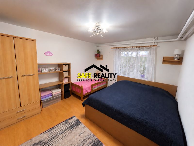 A bedroom in a one-room apartment with shelves, two beds, wooden decor, and a wardrobe.