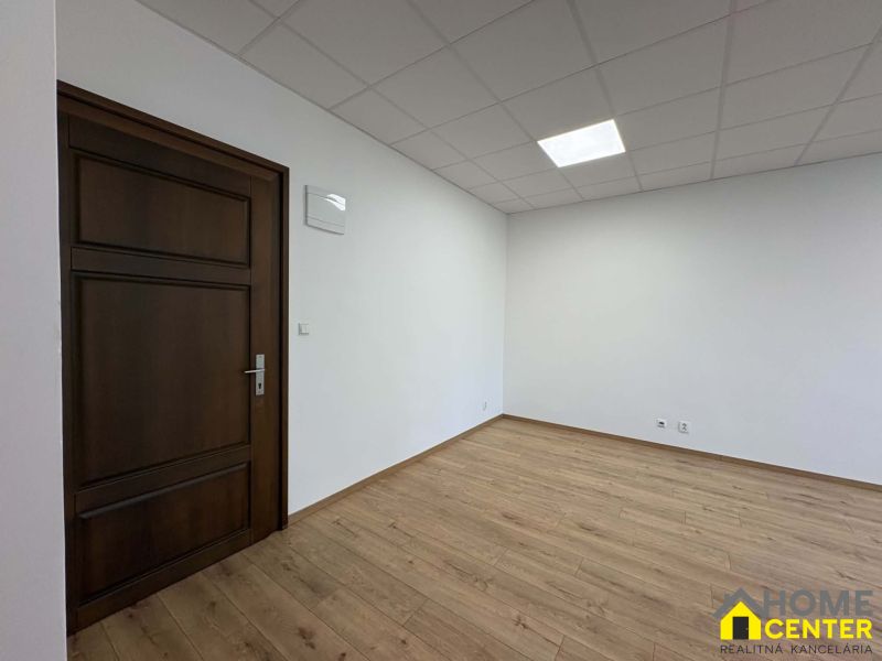A room with a wooden decor floor and closed doors in an office.