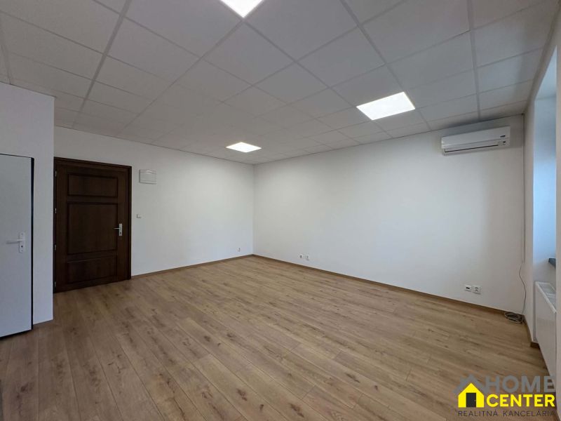 Spacious offices with wood-patterned flooring and white walls.