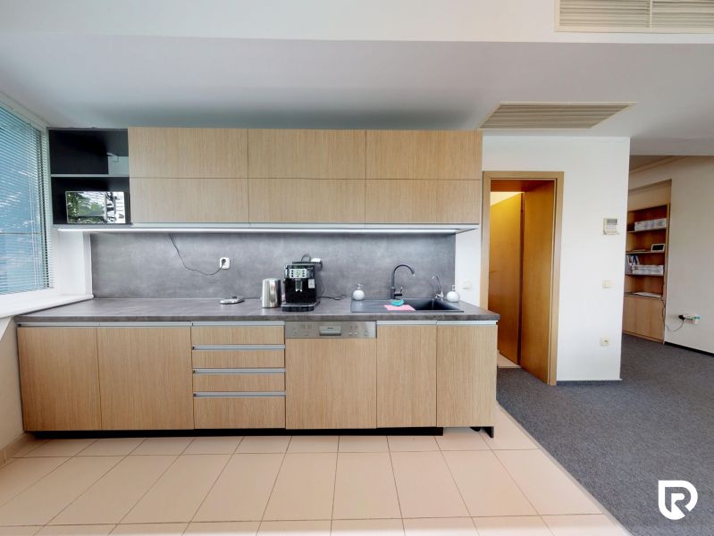 Offices with wood-patterned flooring and a modern kitchen unit.