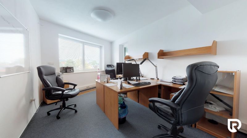 Offices with desks, leather chairs, and a large window, an ideal working environment.
