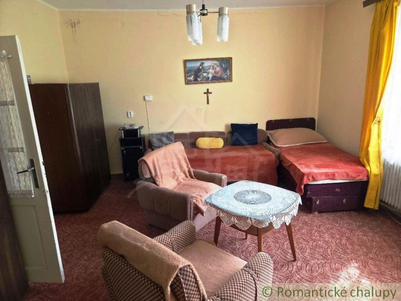Living room of a family house with sofas, armchairs, and decorations on the walls.