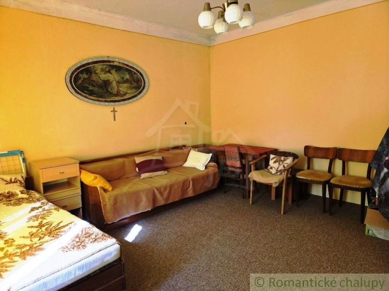 Living room of a family house with furniture, carpet, decorative painting, and chairs.