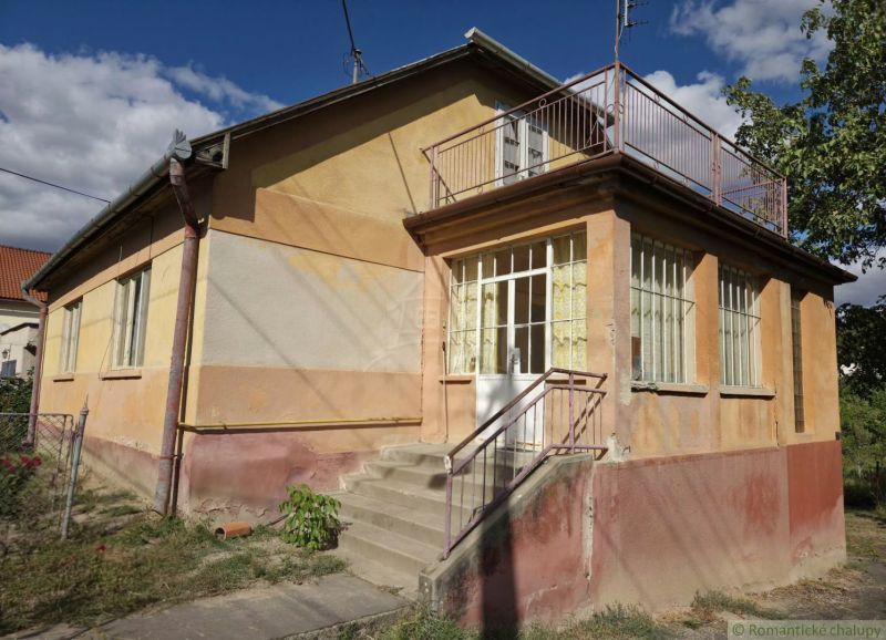 A family house in Sečianky with a glass veranda and staircase.