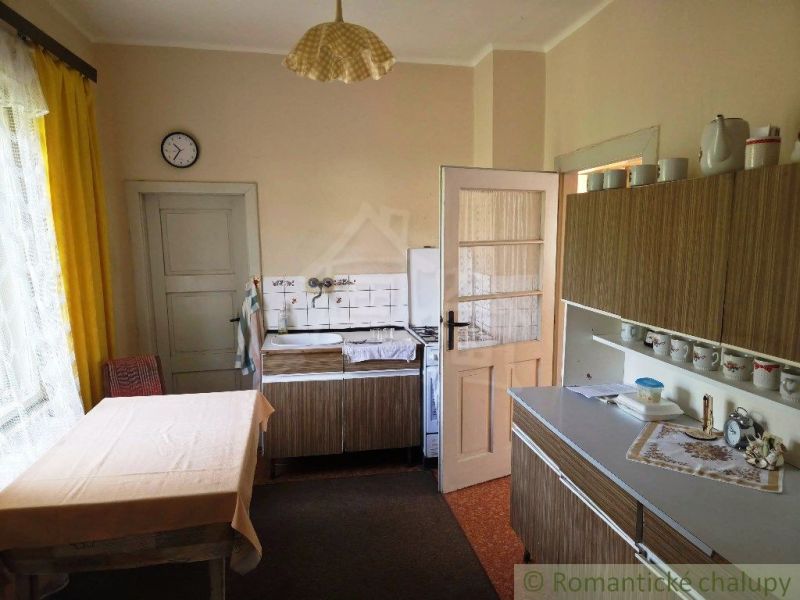 A kitchen in a family house with retro furniture and yellow curtains.