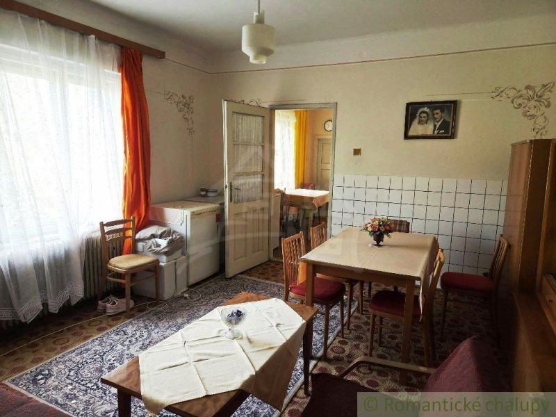 Dining room in a family house with wooden chairs, a table, and a carpet.