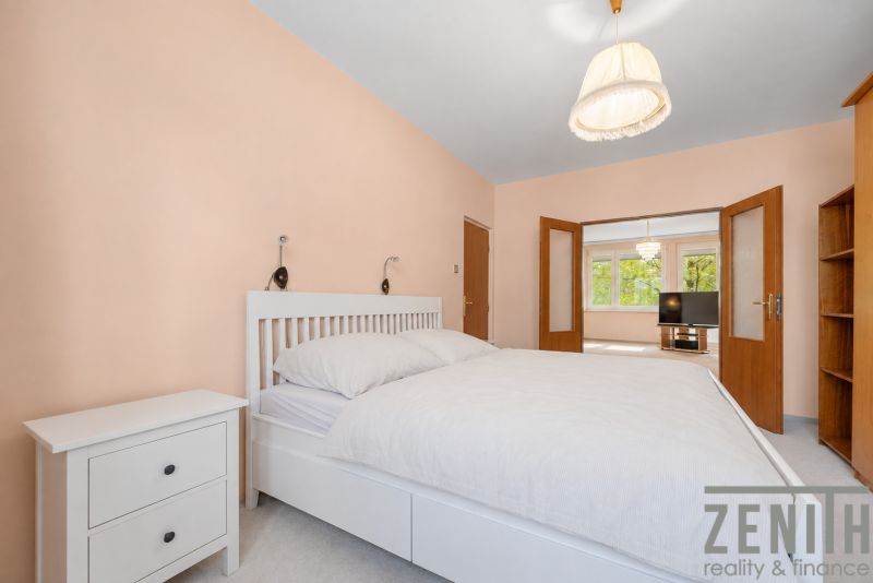 A bright bedroom with white furniture in a 4-room apartment with a view.