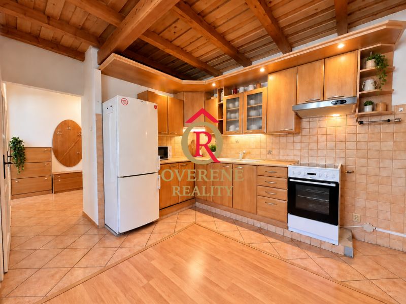 A kitchen in a 2-room apartment with a wooden decor floor and a wooden ceiling.