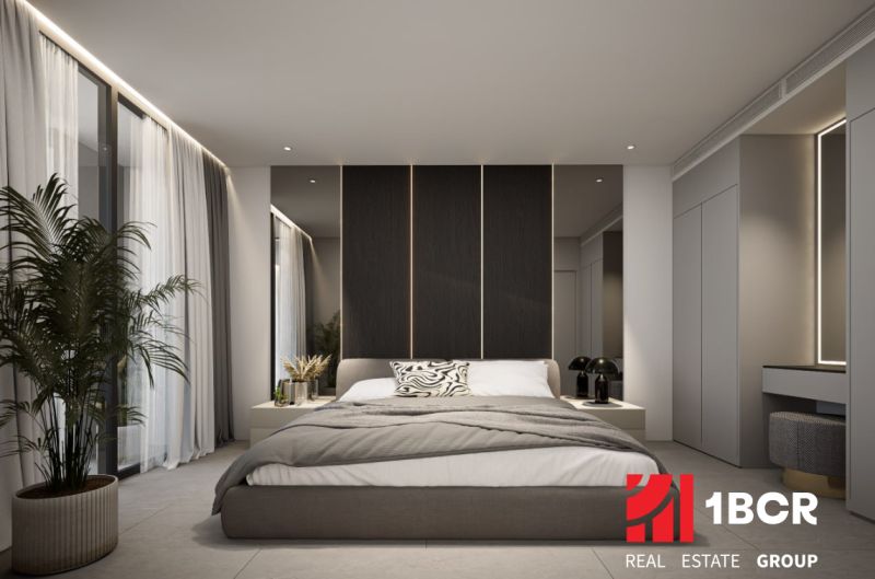 Bedroom in a 2-room apartment with a large bed and decorative lighting.