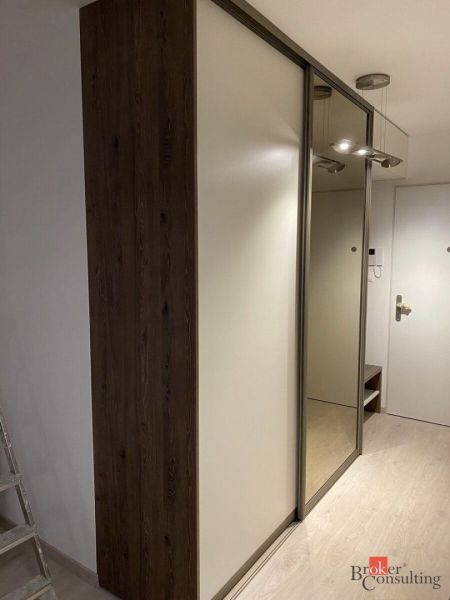 Built-in wardrobe with mirror and floor with wood decor in a 2-room apartment.