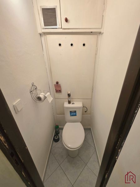 Bathroom with toilet and white walls in a 2-room apartment.
