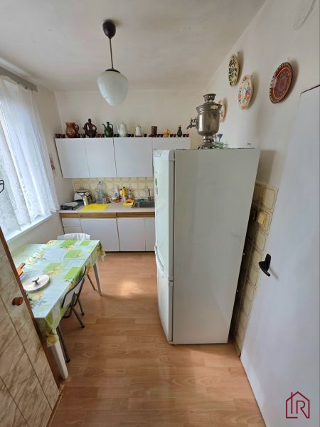 A kitchen in a 2-room apartment with a wooden decor floor and wall plates.