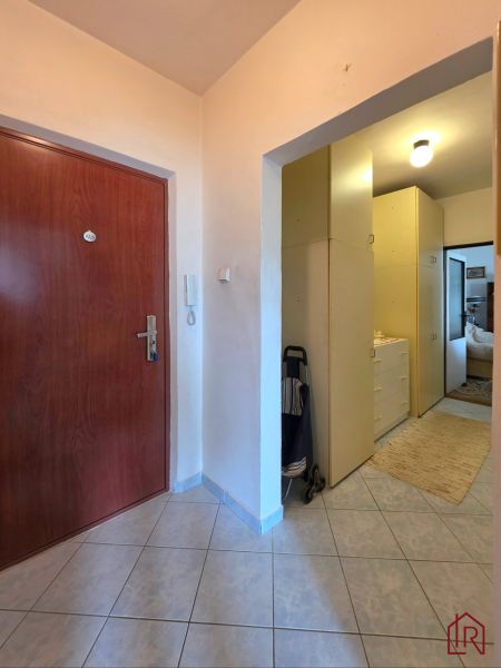 Entrance hallway in a 2-room apartment with tiles and storage spaces.
