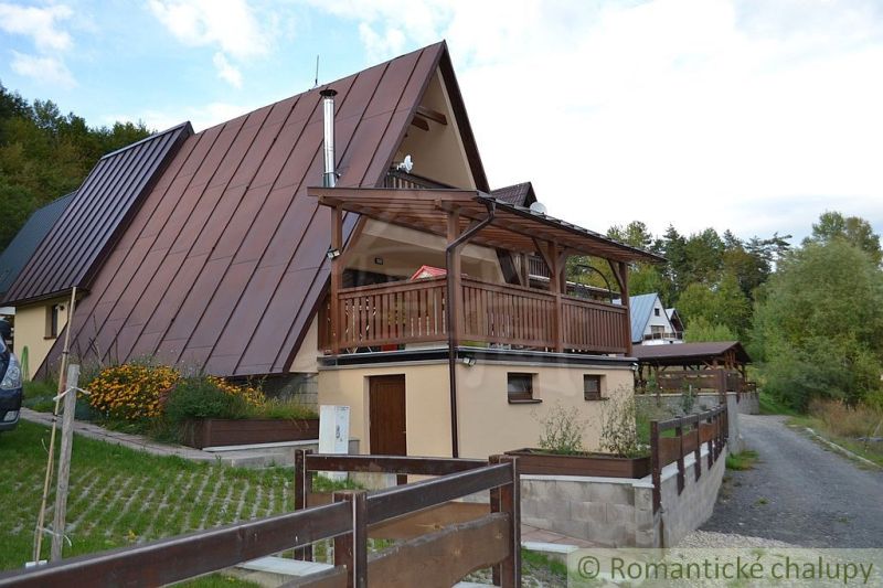 A cottage in Nižná Polianka with a sloped roof and a terrace in a natural setting.