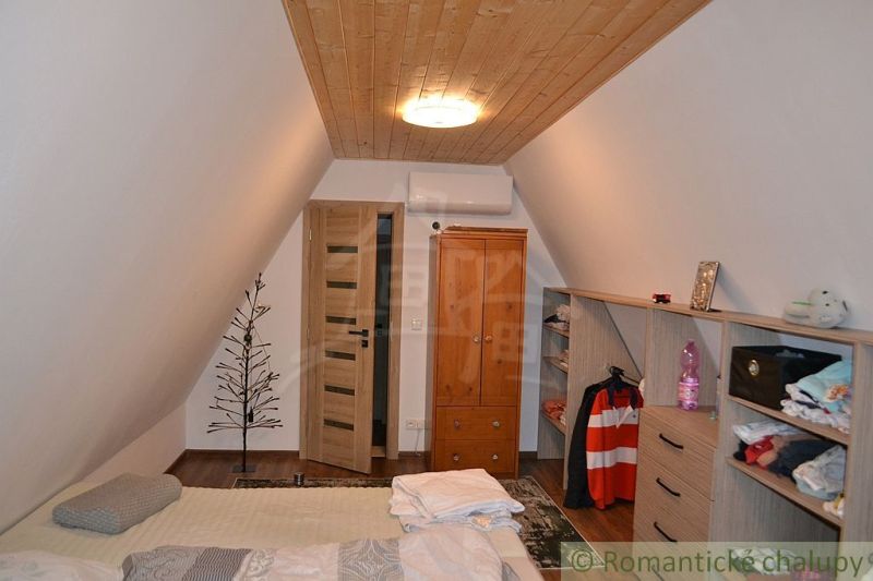 Attic room in a cabin with wooden decor and storage space.