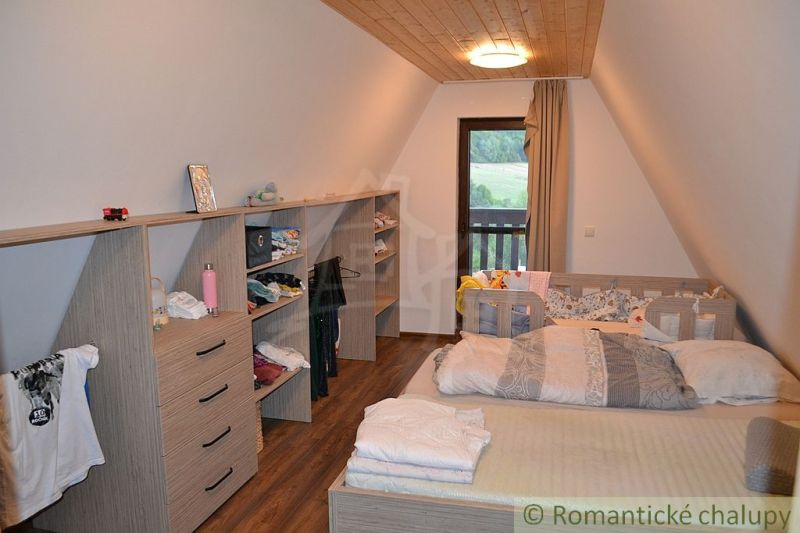 A room in a cottage with a wooden decor floor and storage cabinets.