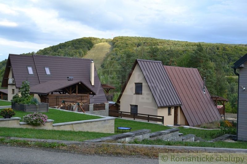 A cottage in Nižná Polianka in the mountains with grassy gardens and modern architecture.