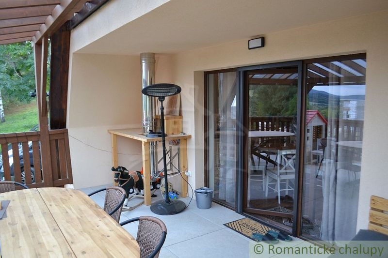 The terrace of the cottage in Nižná Polianka with wooden furniture and a view of the garden.