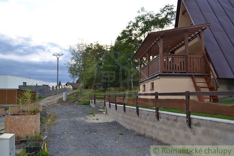 A cottage in Nižná Polianka with a wooden terrace and garden landscaping.