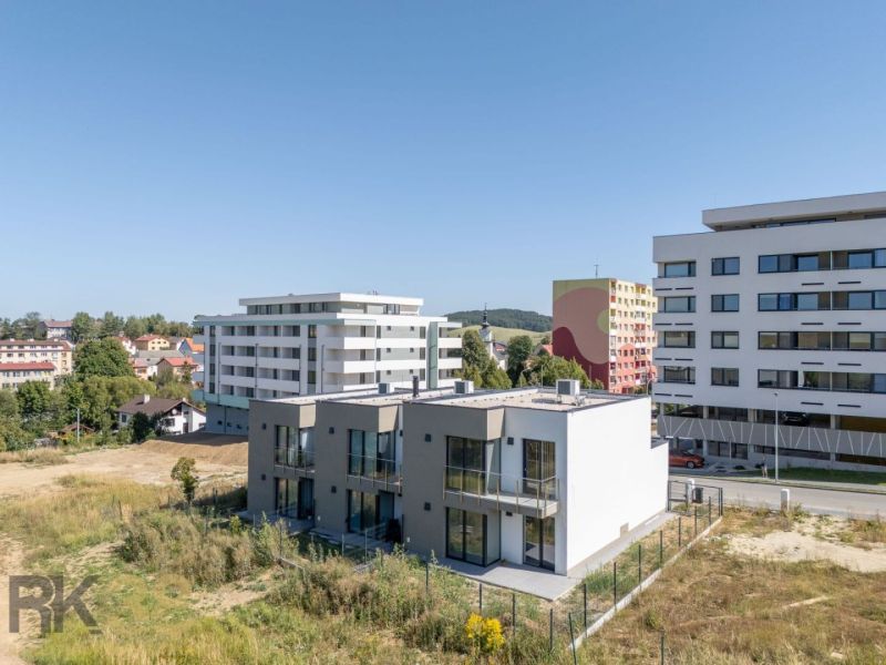 A family house in Poprad with a view of the Tatras, with cars parked in front.