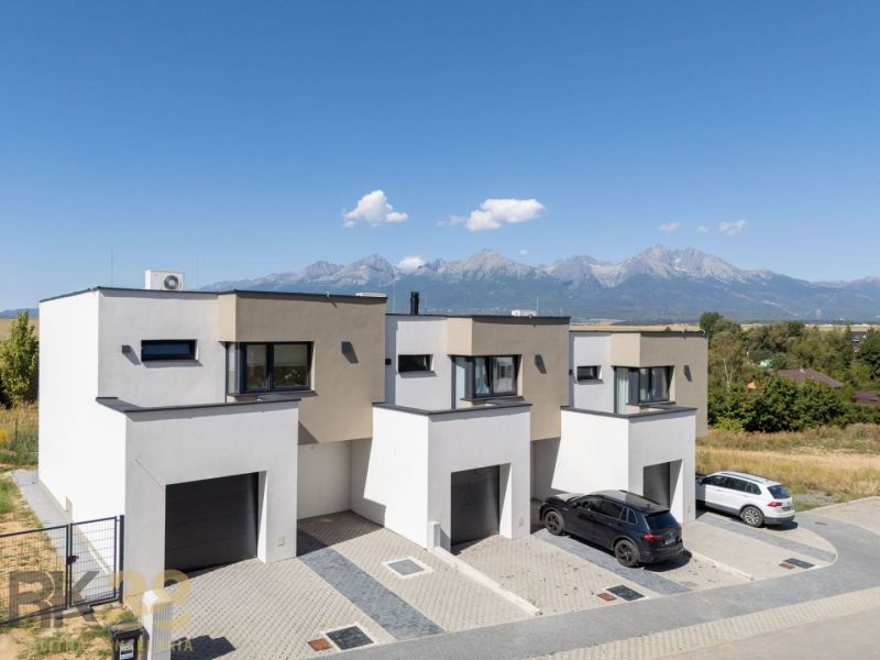 Poprad apartment buildings with the panorama of the High Tatras on the horizon, surrounded by nature.
