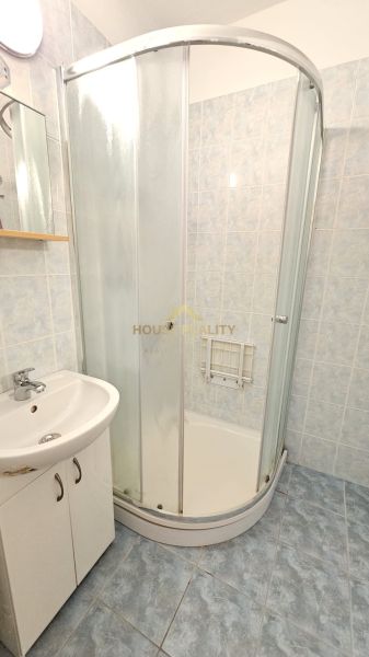 Bathroom with shower and sink in a studio apartment.