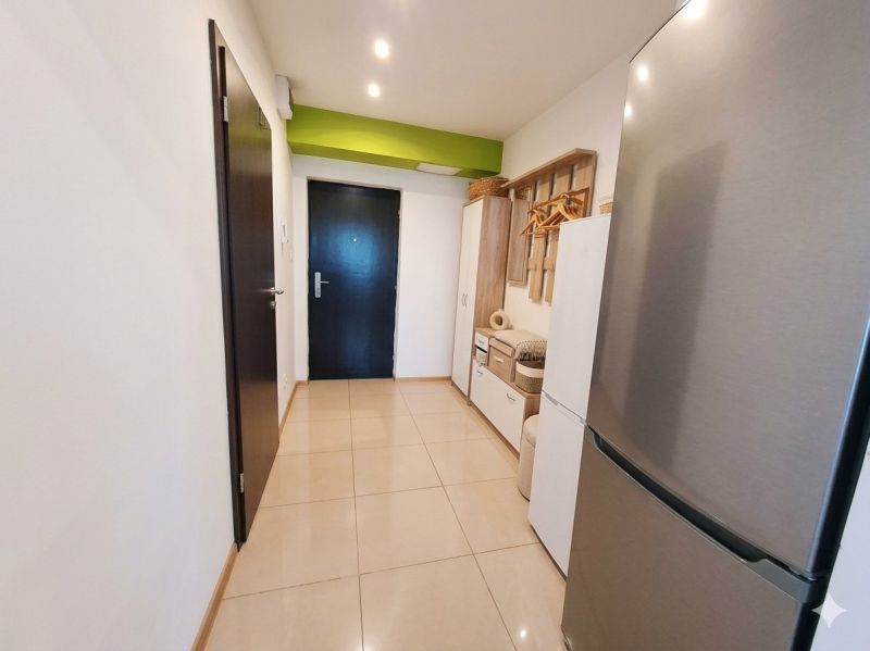 A hallway with light tiles and modern storage space in a 2-room apartment.