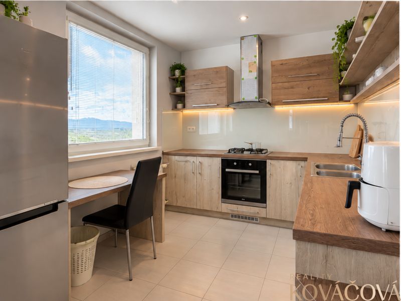 A kitchen with a wooden decor floor in a 4-room apartment, bright and spacious.