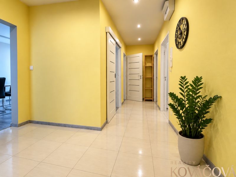 A bright hallway with yellow walls and a houseplant in a 4-room apartment.