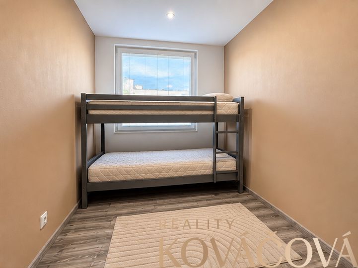A room with a bunk bed in a four-room apartment, floor with wooden decor.