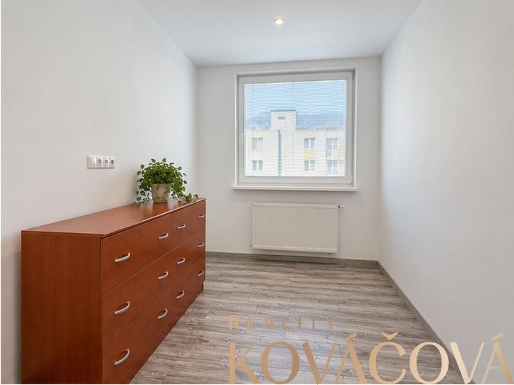 A bright room with a drawer chest and wood-patterned flooring in a 4-room apartment.
