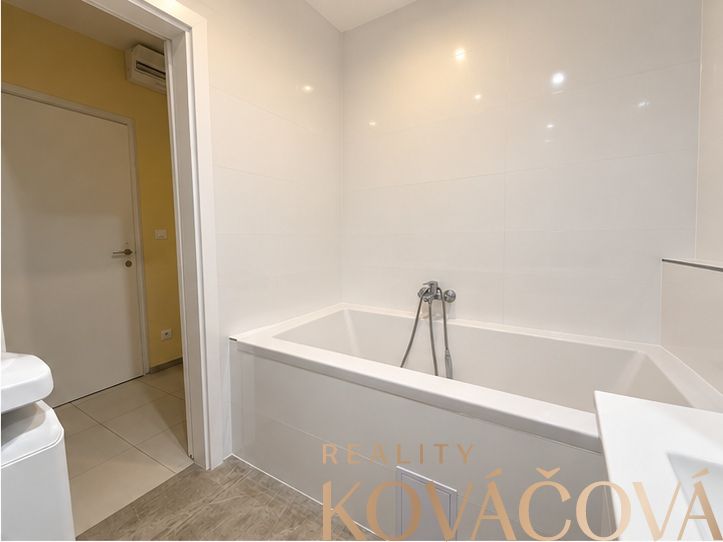 A bathroom with a fresh bathtub and white tiles, 4-room apartment.