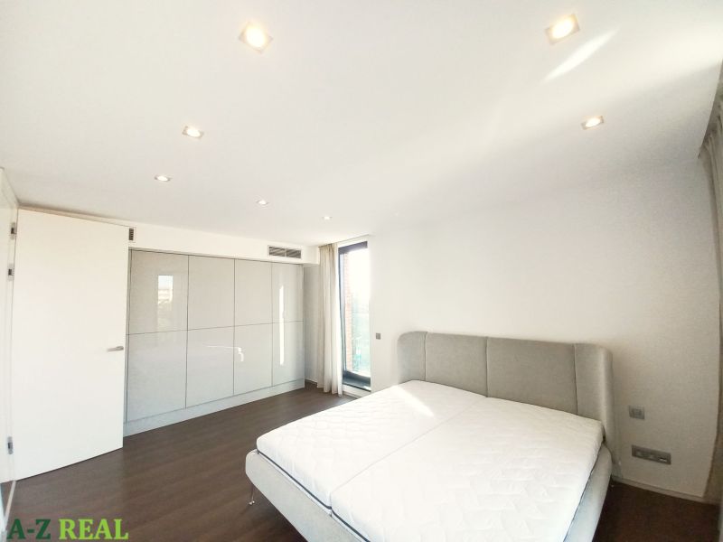 A bedroom in a 4-room apartment with a wooden decor floor and a built-in wardrobe.