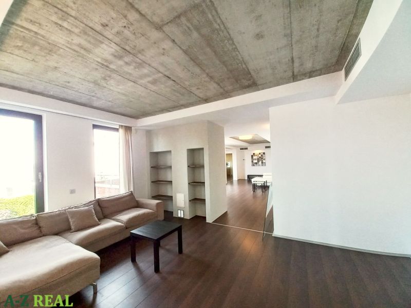 Living room in a 4-room apartment with a wooden decor floor and a sofa.