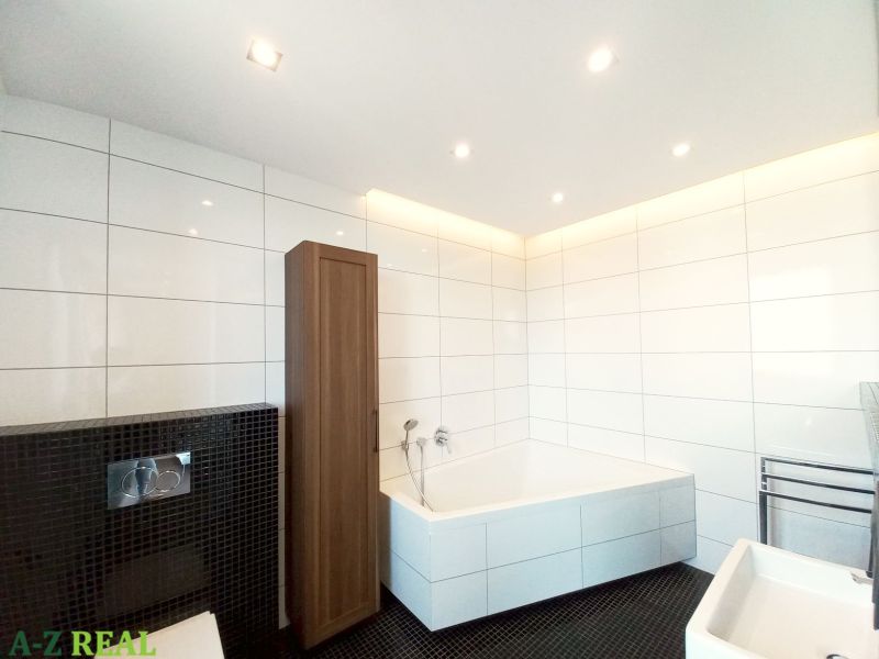 A bathroom with a shower, bathtub, and wooden decor in a 4-room apartment.